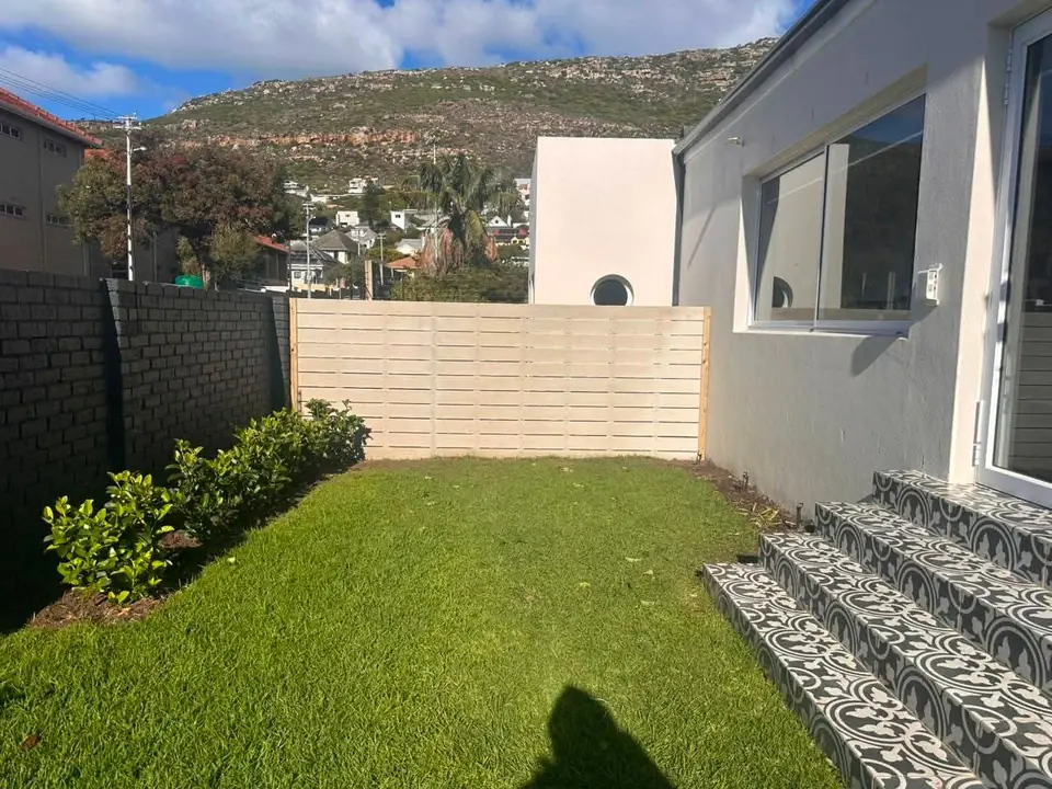 Garden lawn with a slatted fence and patterned tiled steps