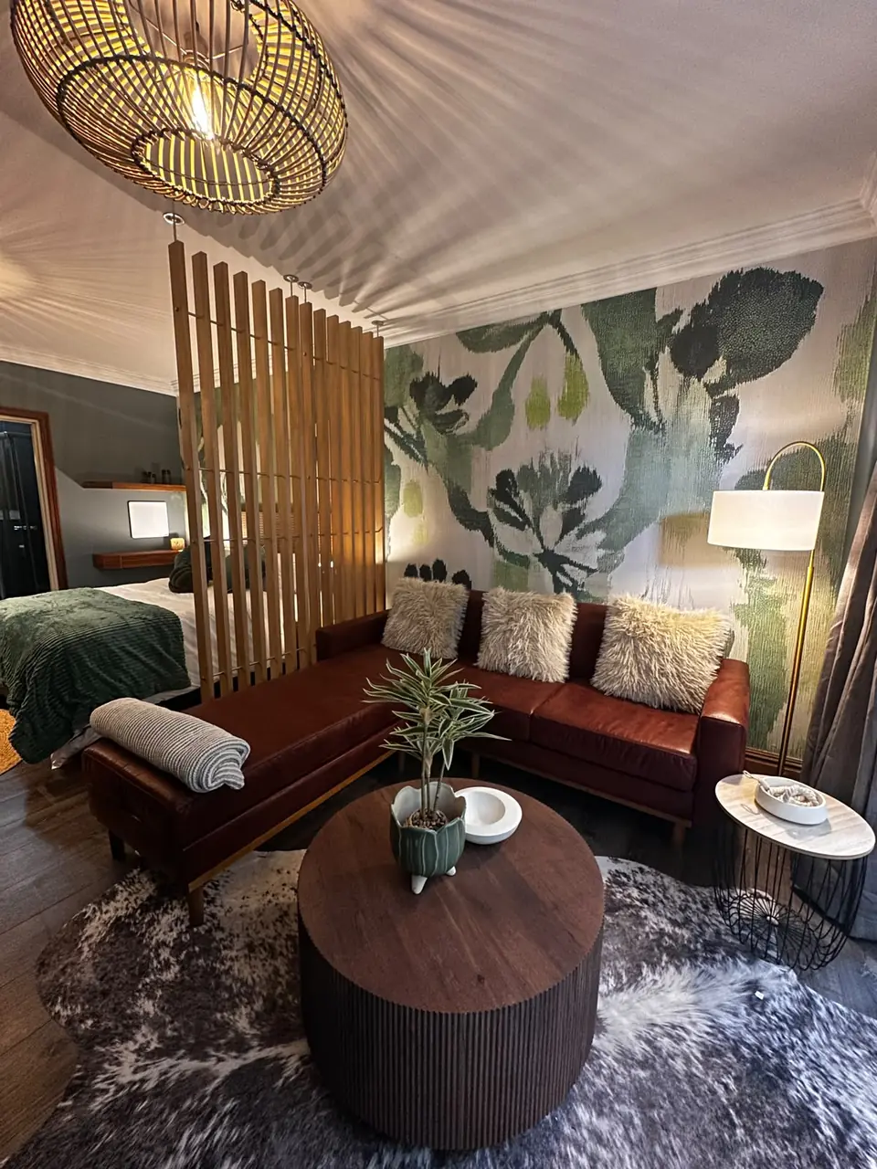 Studio lounge with a slatted timber divider and botanical wallpaper