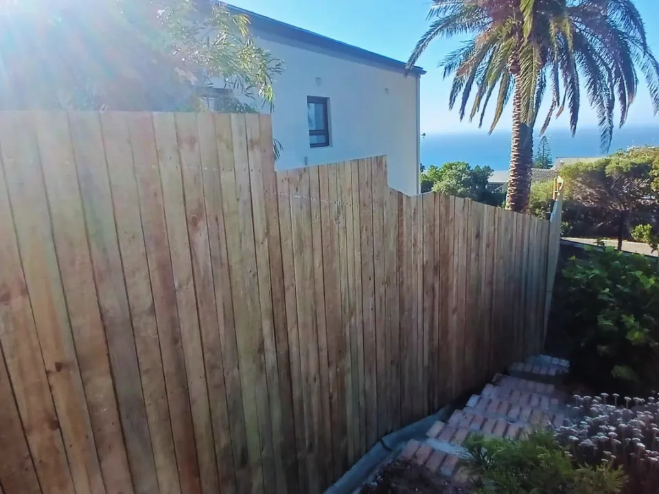 Vertical timber boundary fence in Simon's Town with the sea behind