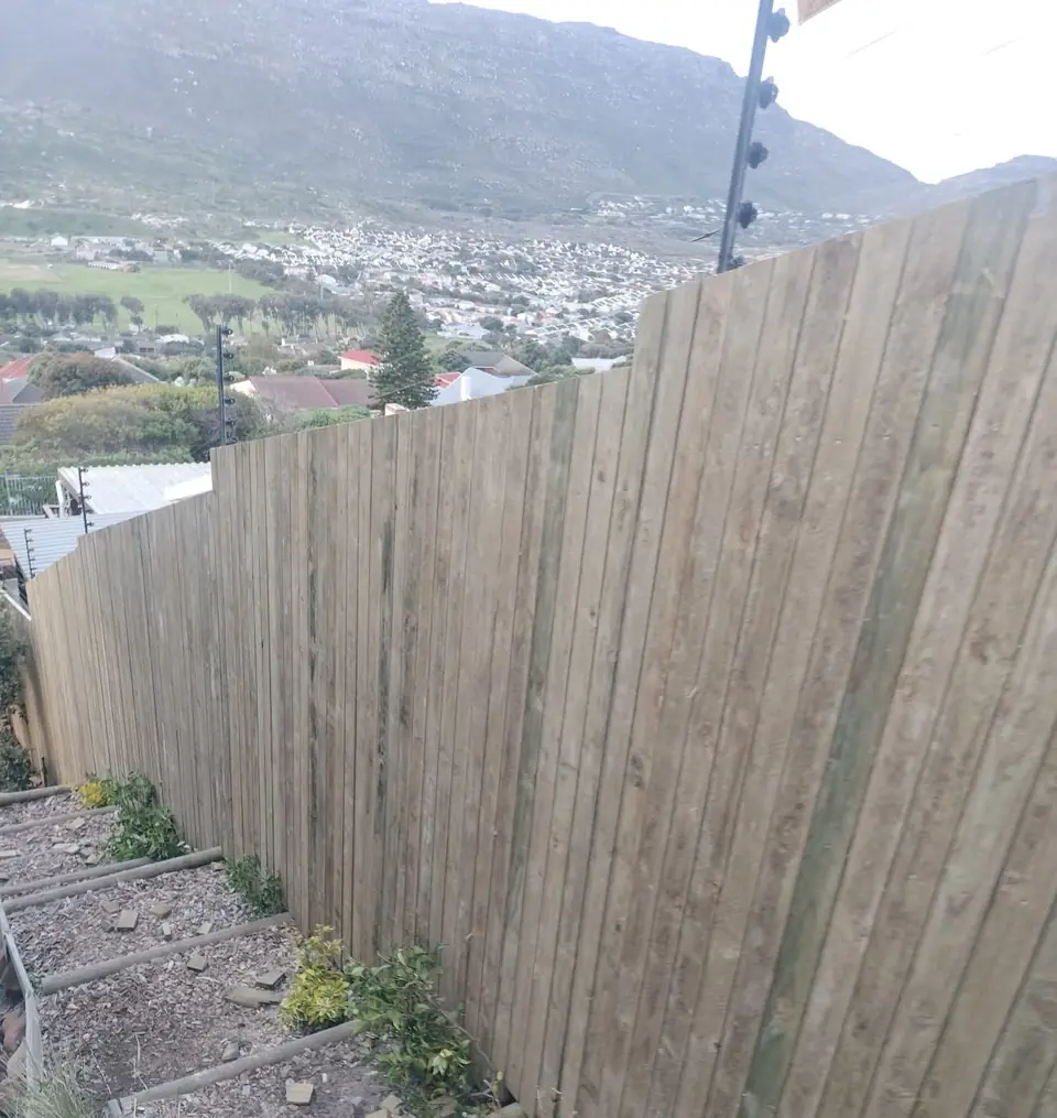 Timber fence on a slope with the mountain and town behind
