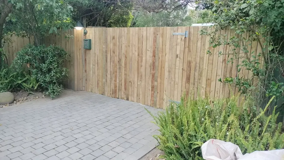 Timber fence around a paved courtyard with planting
