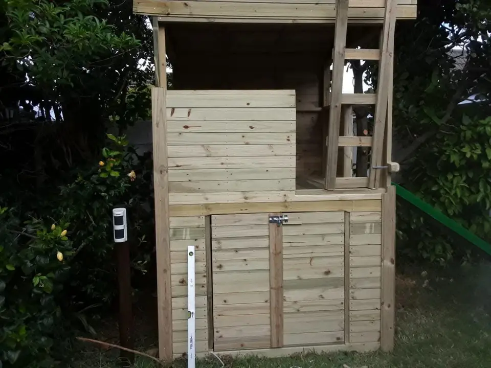 Timber jungle gym with a lockable storage door under the platform, before painting